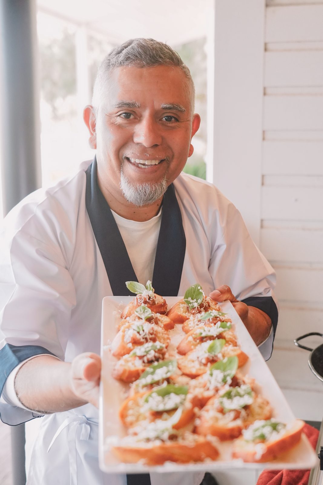 A chef from one of our food partners holding out a tray of bruschetta at the free lunch
