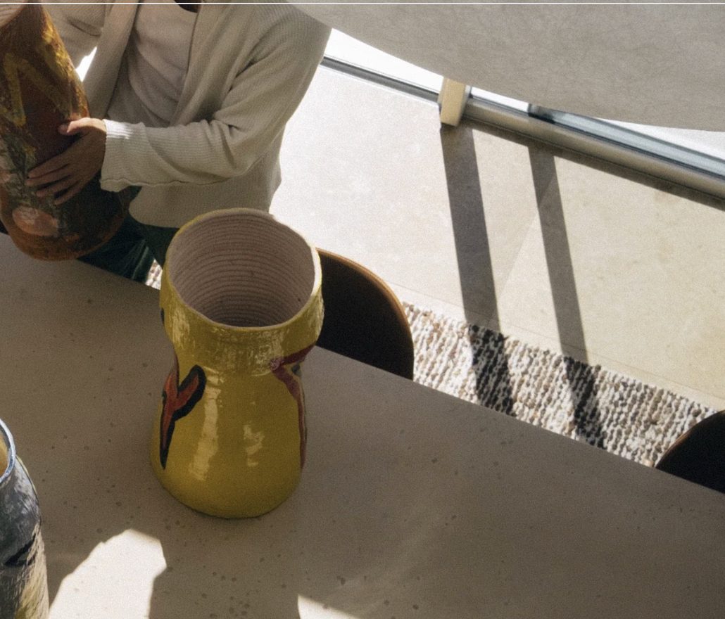 Pottery Boy holding one of his large hand-thrown vessels in the studio